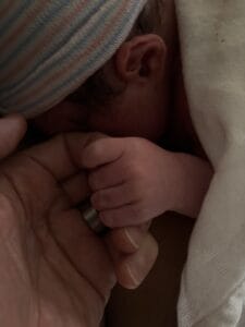 A gentle hand resting over newborn Sophia's torso at the hospital on January 12, 2026